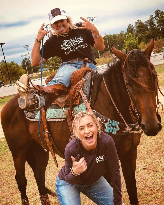Two riders having fun beside a saddled horse